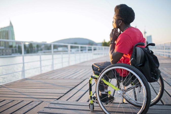 Wheelchair user thinking of ways to nurture mental health and well-being.