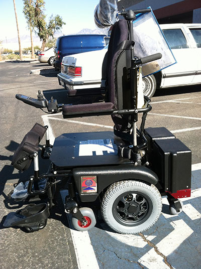 Standing wheelchair in a parking lot.