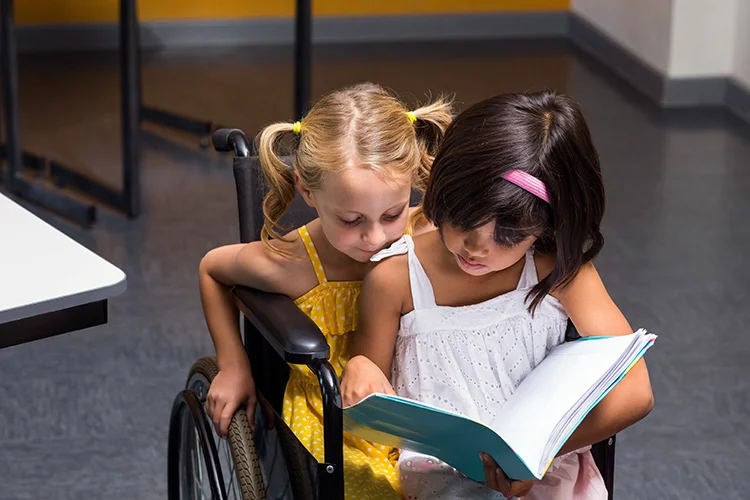 Practice Compassion - Young Girl Reading a Story to Disabled Girl