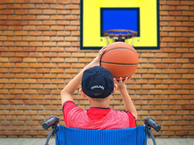 boy playing basketball on his wheelchair - Tips for Parents of Children with Disabilities