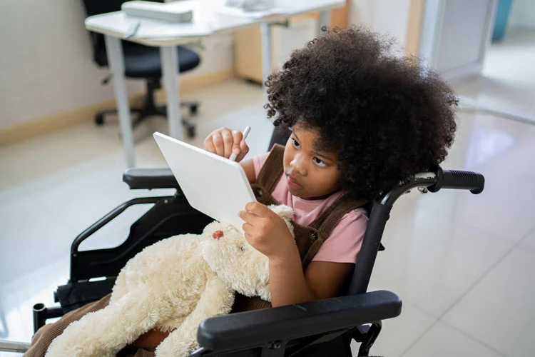 disabled kid with ipad on her wheelchair