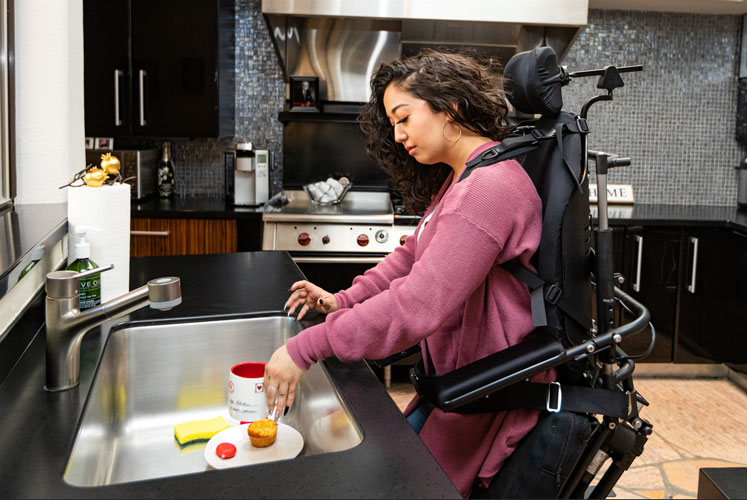 a person on powerchair doing dishes